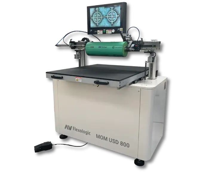 AV Flexologic MOM USD 800 narrow-web flexo plate mounter with a transparent background. Highlights the green mounting cylinder and overhead camera.